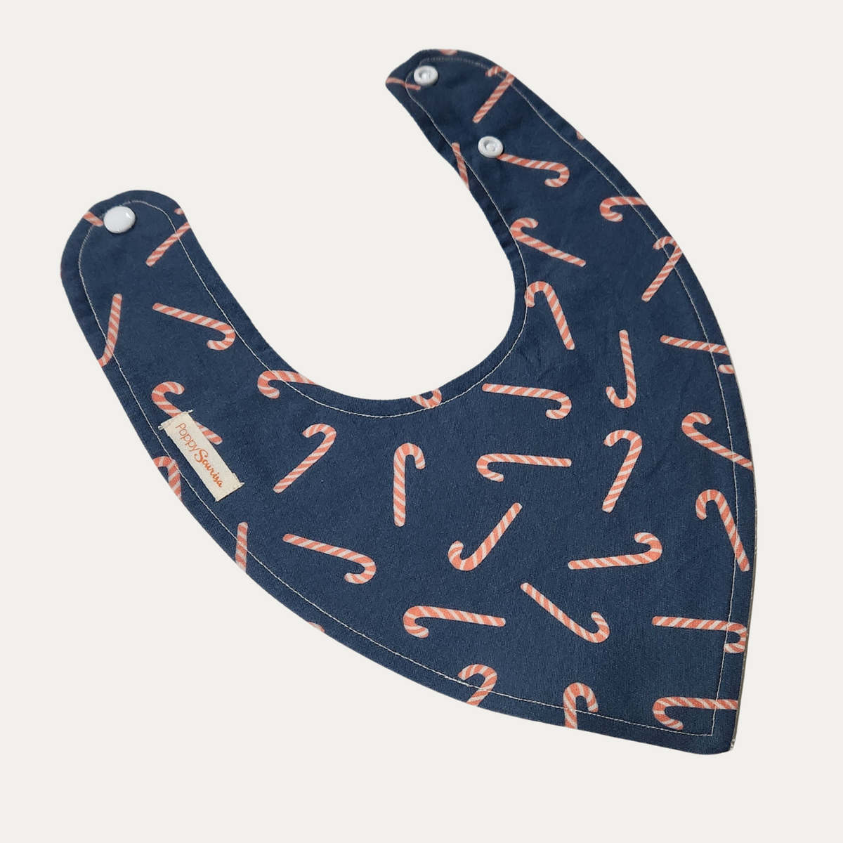 Candy Canes Christmas baby dribble bib featuring coral and white striped candy canes on a navy background.