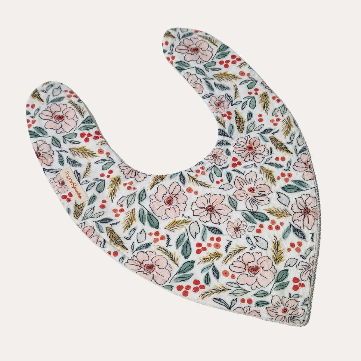 Christmas Floral baby dribble bib featuring pale pink flowers, green foliage and red berries on a cream background.