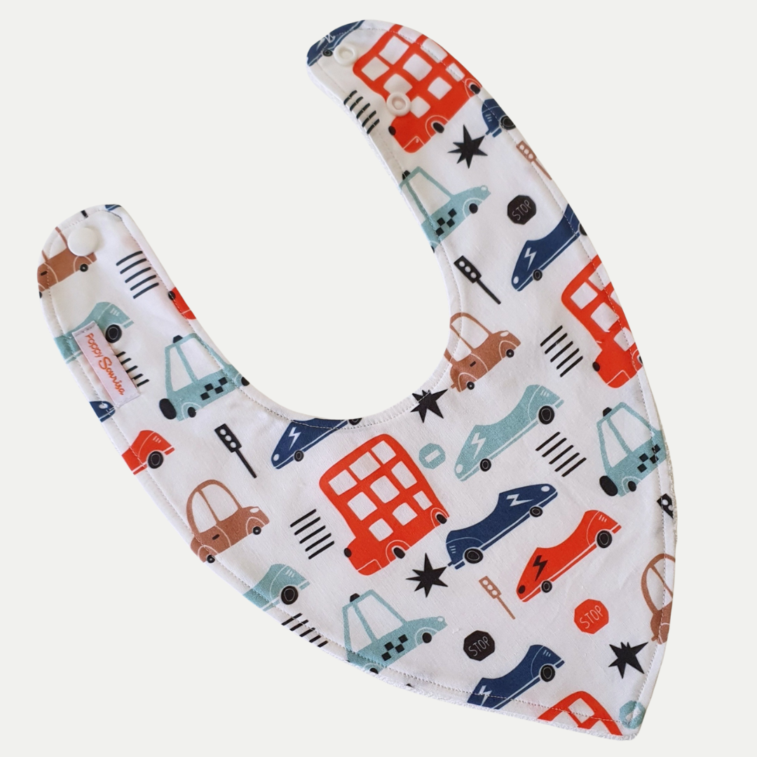 Baby dribble bib with colourful cars, red double-decker buses, traffic lights and road signs on a white background.