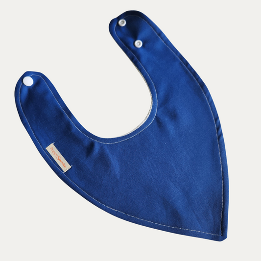 Plain cobalt blue baby dribble bib with white adjustable snaps and stitched edging.