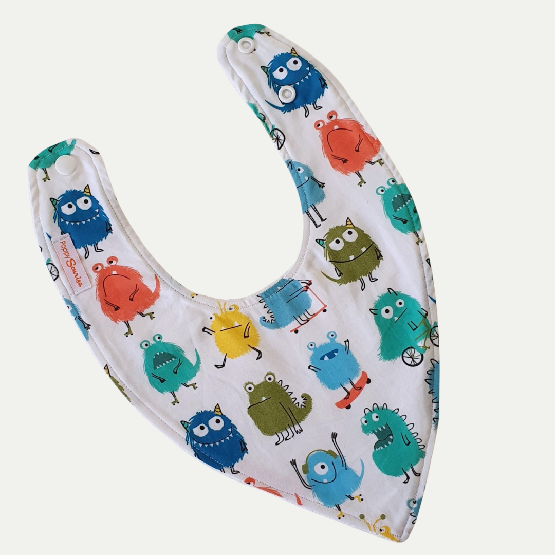 Baby dribble bib with colourful cartoon monsters in blue, teal, orange, yellow and green on a white background.