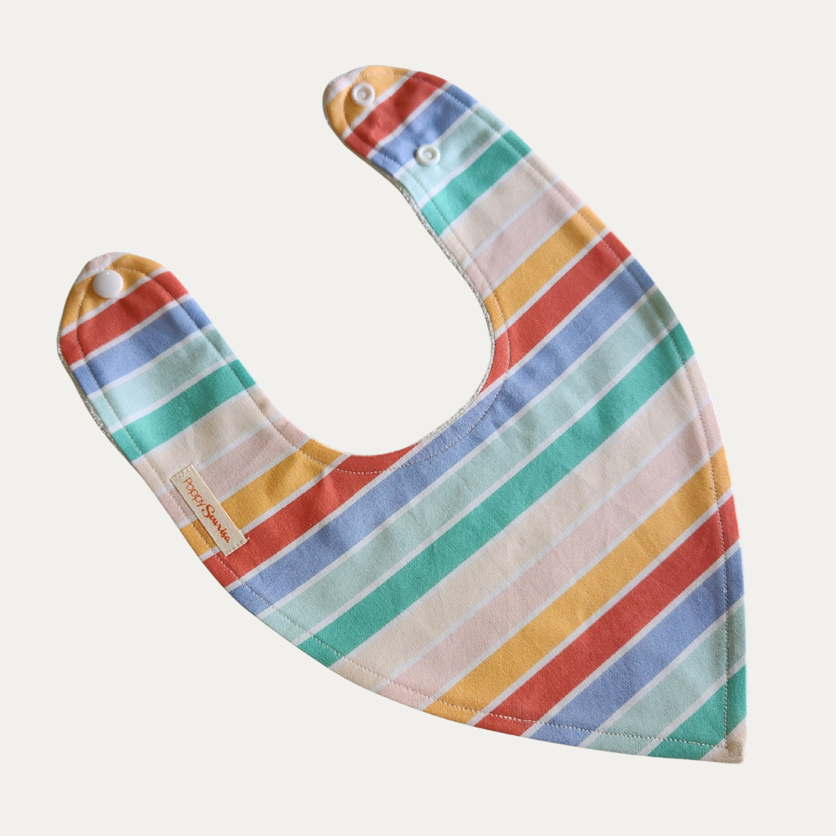Rainbow Stripe baby dribble bib featuring colourful stripes in mustard, coral, blue, mint, teal and pale pink, separated by white lines.