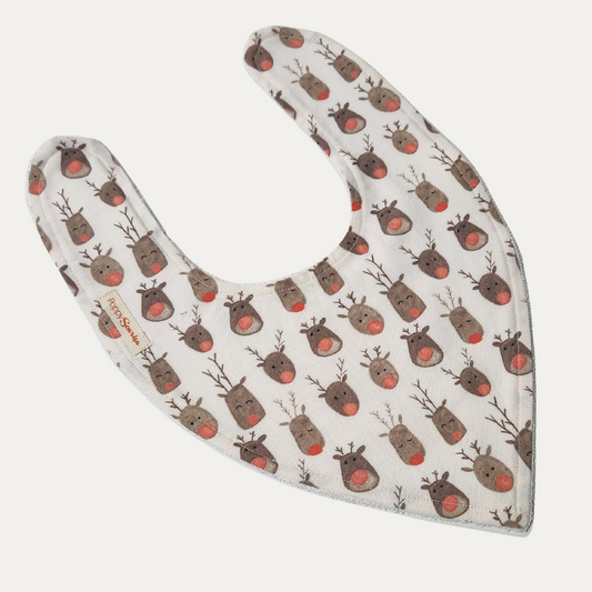 Reindeer Herd Christmas baby dribble bib featuring brown reindeer faces with red noses on a cream background, with adjustable white snaps.