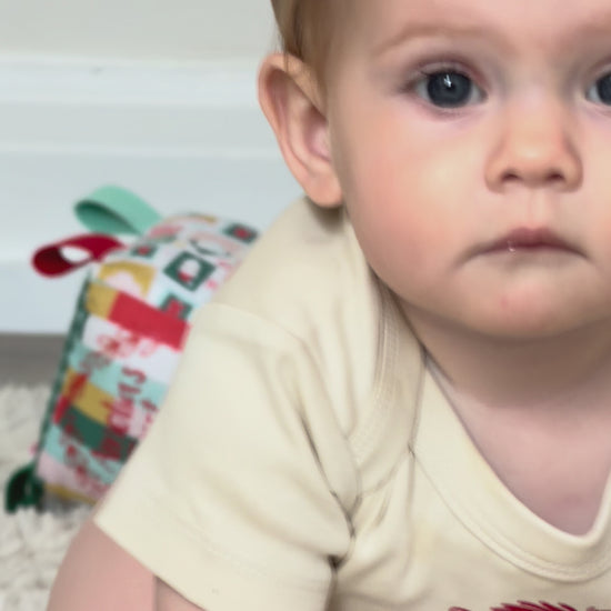 Short video of children with personalised linen Santa Sacks and My First Christmas sensory cubes by the Christmas tree