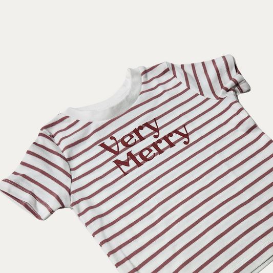 Close-up of the Very Merry kids’ T-shirt, showing the lettering on white fabric with muted red stripes